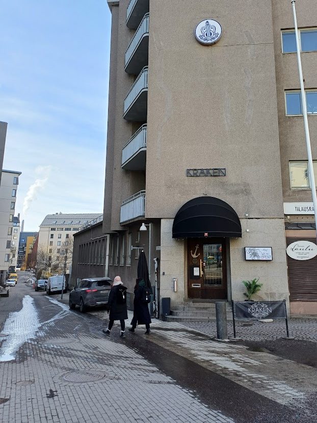Ravintola Krakenin ovi mustan markiisin alla kerrostalon kulmassa. Talon vasemmalla puolella Leppäsuonkatu laskee alamäkeen.