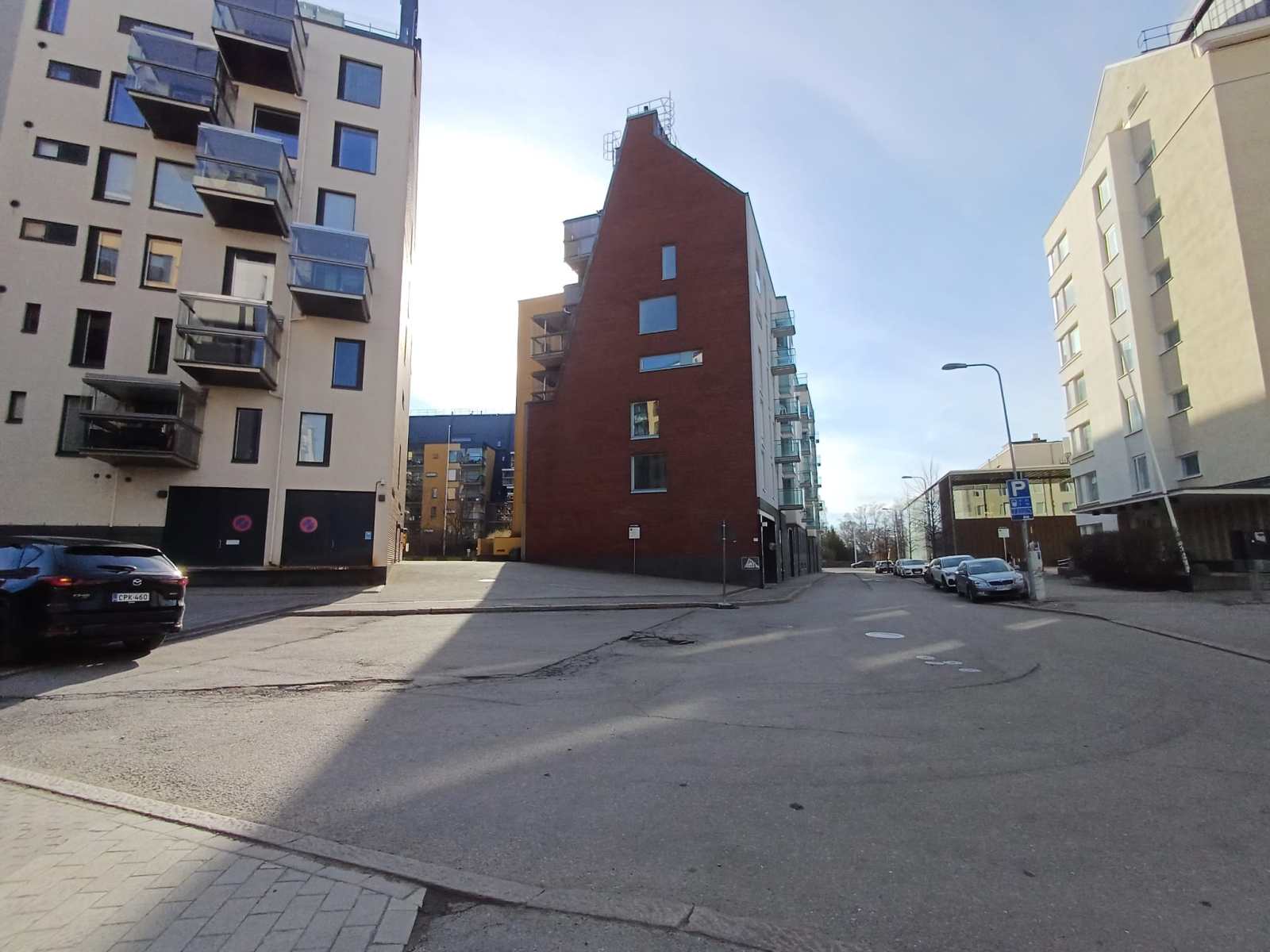 Risteys, jonka keskellä on punatiilinen kerrostalo. Sen oikealla puolella näkyy kauempana tien varressa matala ruskea Domus Gaudium.